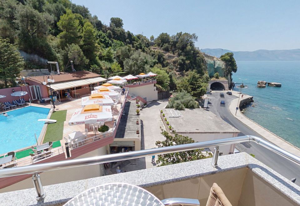 a balcony overlooking a beautiful view of a resort with umbrellas and chairs , overlooking the ocean at Hotel New York