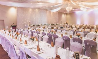 a large banquet hall filled with tables and chairs , ready for a wedding reception or other formal event at Sage Hotel Wollongong