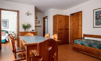 a dining room with a wooden dining table , chairs , and a couch in the background at Hotel Cristallo