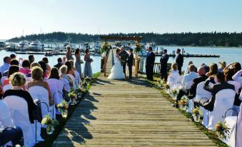 a wedding ceremony taking place on a dock , with the bride and groom standing at the altar at Lopez Islander Resort