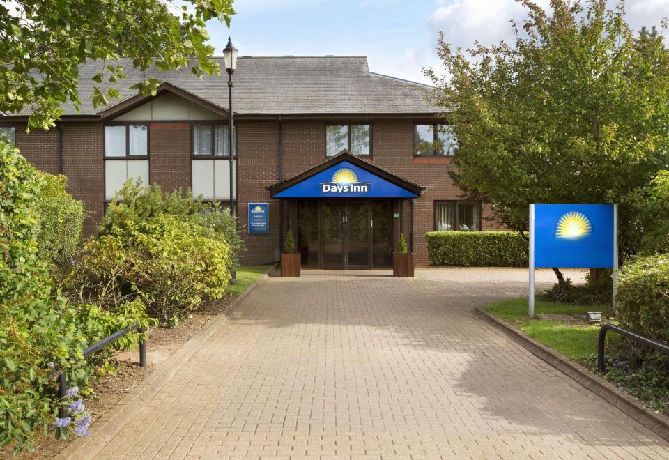 "a brick building with a blue door and a sign that says "" days inn "" on it" at Days Inn by Wyndham Taunton