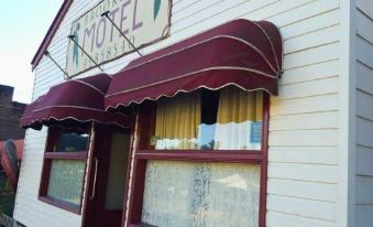 "a small hotel with a red awning and a sign that reads "" the west coast motel .""." at Brooklyn Motel