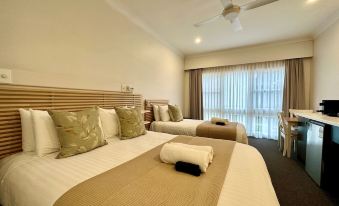 a hotel room with two beds , one on the left and one on the right side of the room at Berrima Bakehouse Motel