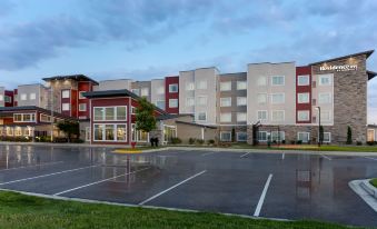 a large apartment building with multiple balconies and windows , surrounded by grass and trees , and a parking lot in front at Residence Inn Upper Marlboro Joint Base Andrews