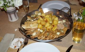 a dining table with a variety of food items , including a plate of meat and potatoes at Hohenstein