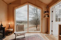 Tiny cabin amongst trees on a farm with alpacas