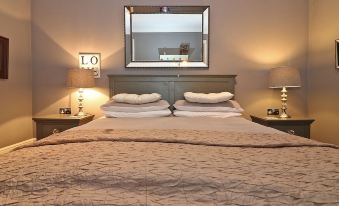 a bed with a wooden headboard and white linens is shown in a bedroom with lamps on either side at Ocean View