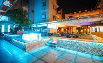 a night view of a restaurant with blue lights and an outdoor area with a water fountain at Malligi,Hampi