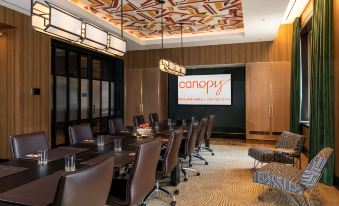 "a conference room with a large table , chairs , and a projector screen displaying the word "" canopy ""." at Canopy by Hilton Philadelphia Center City