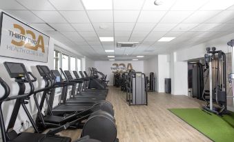 a gym with various exercise equipment and a green mat in the middle of the room at Springfield Hotel and Restaurant