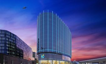 A large building with an illuminated exterior and a blue sky in the background at Regala Skycity Hotel