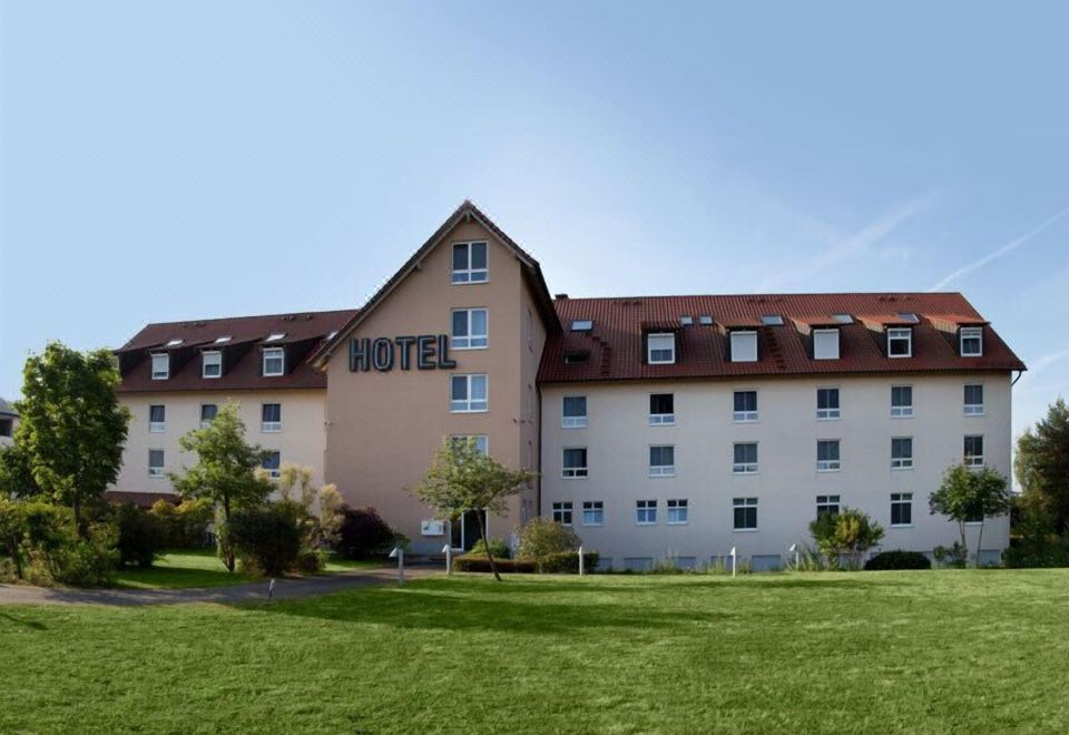 "a large hotel with a red roof and the word "" hotel "" on top of it" at Fairway Hotel