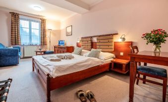 a well - decorated hotel room with a large bed , wooden furniture , and a tv on the wall at Hotel Golfer