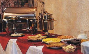 a dining table with a variety of food items , including pizza , salads , and other dishes at Sonata