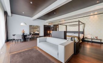 a modern living room with a white couch , wooden floors , and a dining area in the background at Devero Hotel Spa, BW Signature Collection
