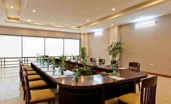 a conference room set up for a meeting , with tables and chairs arranged in rows at Muong Thanh Dien Chau Hotel