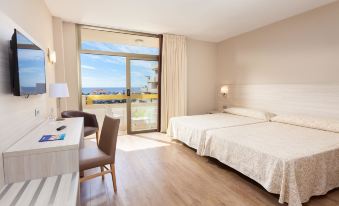 a hotel room with two beds , a desk , and a sliding glass door leading to a balcony at Hotel Best Tenerife