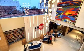 a modern building with a large window and colorful ceiling art , including a logo for crf hotel at Citihub Hotel @Kediri