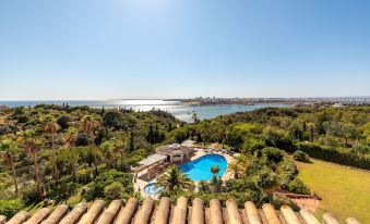 a beautiful villa with a pool and tropical gardens , overlooking the ocean and other buildings in the distance at Hotel Casabela