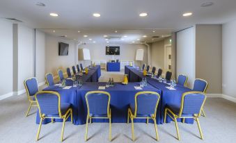 a conference room set up for a meeting , with chairs arranged in a semicircle around a long table at The Ellison