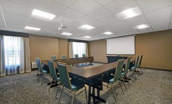 a conference room with a long table , chairs , and a projector screen , ready for a meeting or presentation at Homewood Suites by Hilton Chicago-Lincolnshire