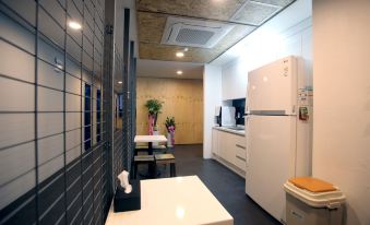 a dining area with white walls and small tables adjacent to the refrigerator at KSTAR METRO Hotel