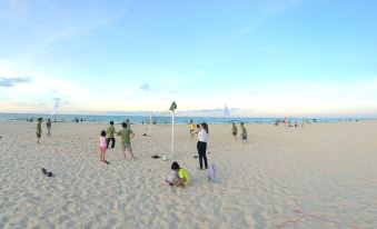 a group of people are playing beach volleyball on a sandy beach under a blue sky at Sepon Boutique Resort