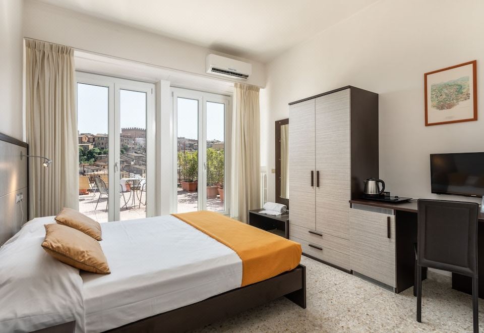 a spacious bedroom with a large bed , a dresser , and a door leading to a balcony at Hotel Minerva