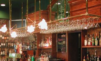 a well - stocked bar with various bottles and glasses , as well as a variety of alcoholic beverages at The Brick Hotel