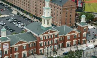 aerial view of a brick building with a tower and a clock on the side , surrounded by cars at Courtyard Baltimore Hunt Valley