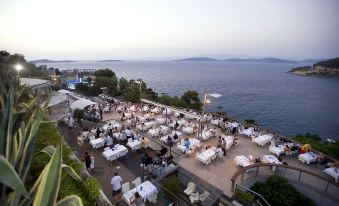 a large outdoor dining area with tables and chairs set up for a group of people to enjoy a meal at Duja Bodrum