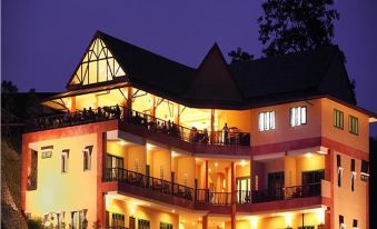 a large building with multiple floors and balconies lit up at night , creating a picturesque scene at Samprasob Resort