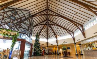 a large , open - air atrium with a high ceiling and wooden beams , decorated for the christmas season at Horison Ultima Bandung