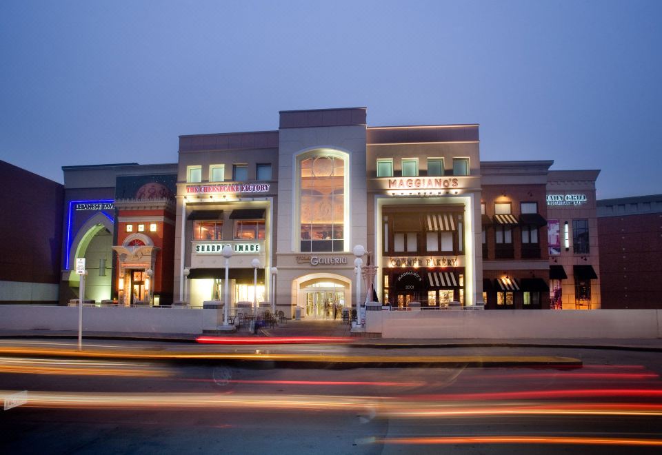 a modern shopping mall with multiple entrances and a road in front of it , illuminated at night at SpringHill Suites Centreville Chantilly