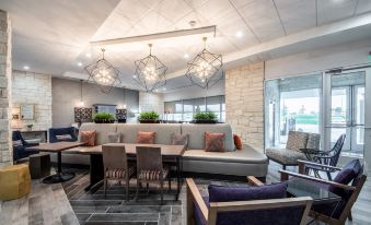 a modern living room with a couch , chairs , and dining table is shown in the image at Home2 Suites by Hilton Fort Worth  Northlake