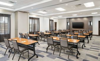 a large conference room with rows of chairs arranged in a semicircle , and a tv mounted on the wall at Hyatt Place Melbourne / Palm Bay / I-95