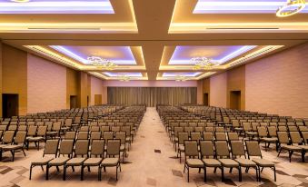 a large conference room with rows of chairs arranged in a symmetrical fashion , illuminated by ceiling lights at Hyatt Regency Andares Guadalajara