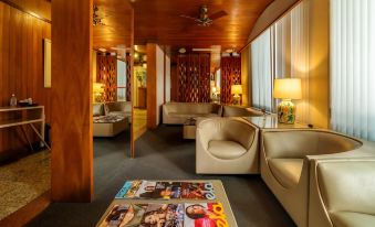 a cozy living room with various furniture , including couches , chairs , and a dining table , as well as magazines and pictures on the walls at Infinity Copacabana, Ex-APA Hotel