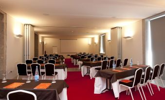 a conference room set up for a meeting , with tables and chairs arranged in rows at Pousada De Viseu