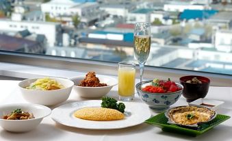 a table is set with various dishes , including a bowl of soup and a glass of champagne at Hotel Aomori