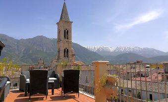 a view of a church tower from a rooftop terrace with mountains in the background at Legacy