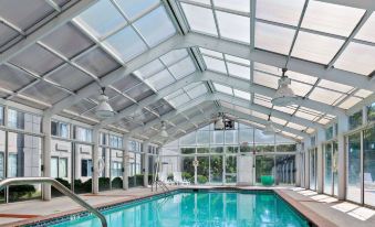 an indoor swimming pool with a glass ceiling , allowing natural light to fill the space at Wyndham Garden Manassas