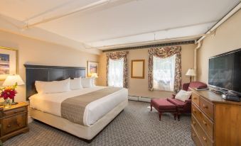 a spacious hotel room with a large bed , white linens , and a tray on the bed at Eagle Mountain House and Golf Club