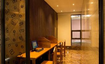 a room with wooden walls and a table , chairs , and a laptop on the table at The Home Hotel