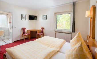 a hotel room with two beds , one on the left and one on the right side of the room at Hotel zur Post
