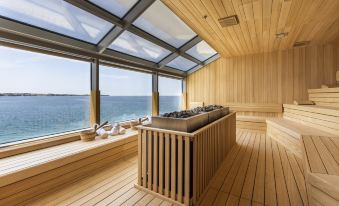 a wooden deck with a large window overlooking the ocean , providing a beautiful view of the sea at Hotel Histrion