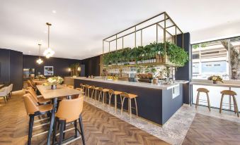 a modern coffee shop with a bar counter and seating area , where customers can enjoy their drinks and snacks at Vibe Hotel Sydney