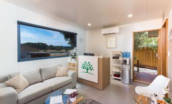 a cozy living room with a couch , a coffee table , and a tv . also a kitchen in the background at The Swan Valley Retreat