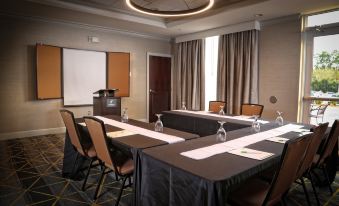 a conference room set up for a meeting , with tables and chairs arranged in a semicircle at Holiday Inn Statesboro-University Area