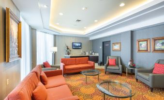 a modern living room with orange furniture , a large window , and a flat screen tv at Hôtel WelcomInns
